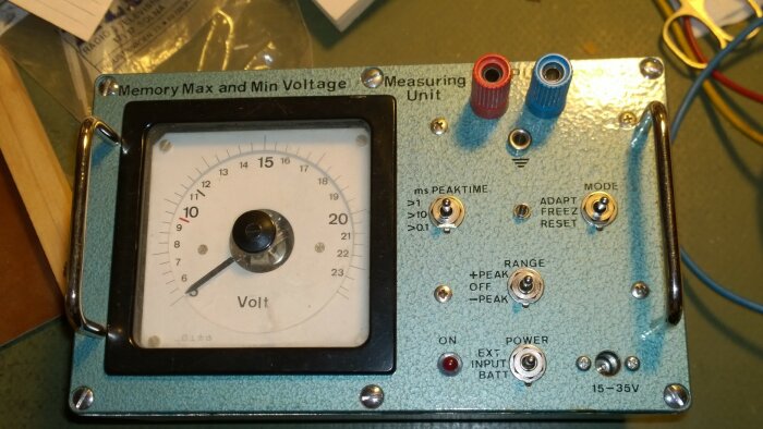 Analogt instrument för mätning, knappar, vred, banankontakter, skrivet "Volt", inställningar för min/max och brytare.