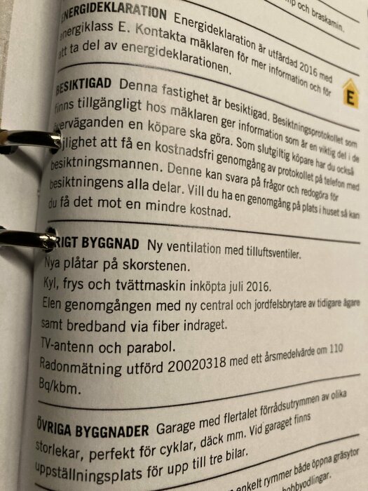 Svart glasögonbåge vilar på ett dokument med text på svenska om fastighet, energideklaration och husbesiktning.