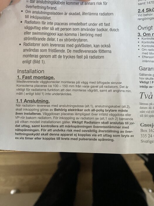 Instruktionsblad för installation av radiator, säkerhetsvarningar och krav på väggavstånd synliga.