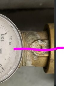 Manometer med skala, ansluten till rörledning med läckage, isoleringsskum synligt, installationsdetalj, underhållsbehov.