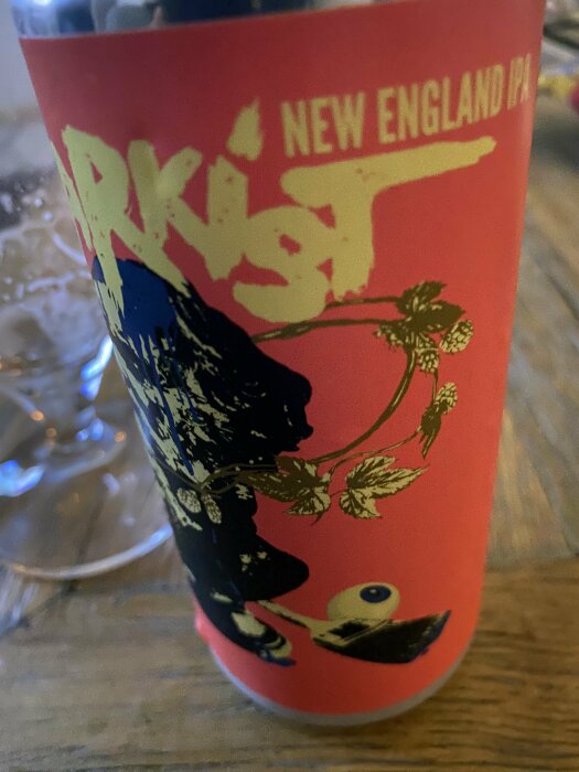 Burk med grafisk design, "New England IPA" text, delvis suddig.