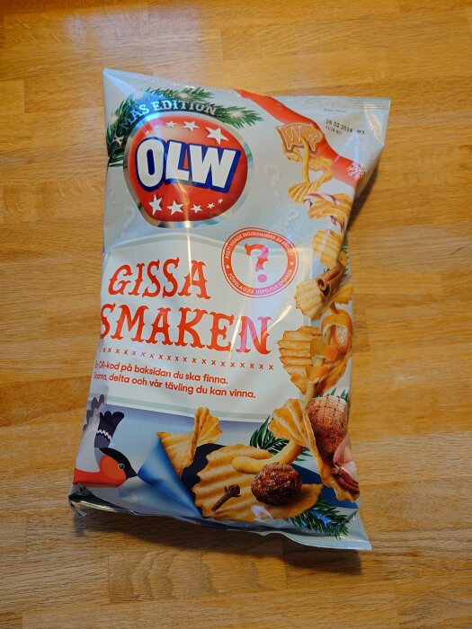 OLW-chipsförpackning, "Gissa Smaken" kampanj, juledition, trägolv, matbilder, QR-kod, tävlingsdetaljer, granrisdekor.