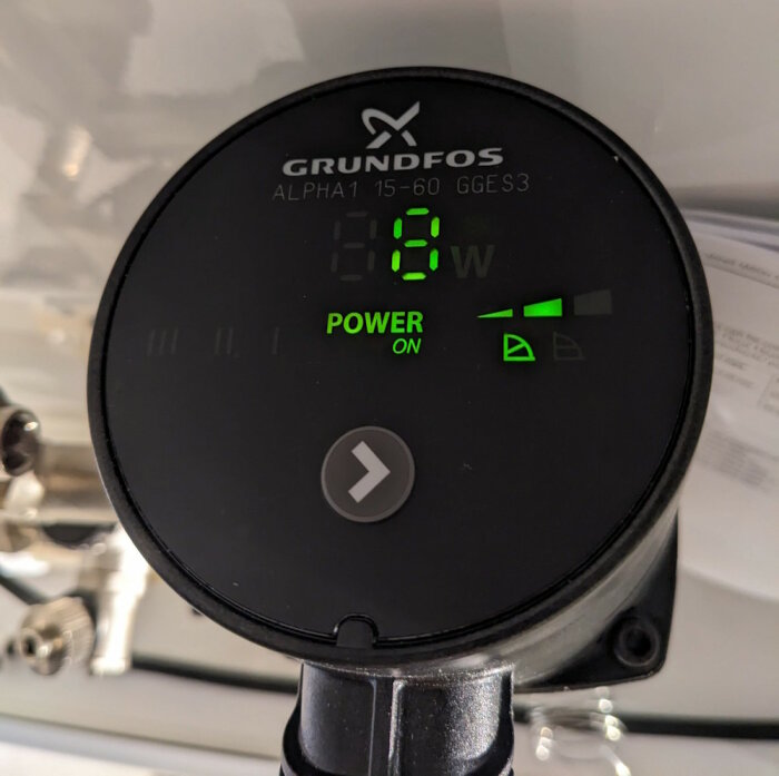 Digital display på en Grundfos Alpha1 cirkulationspump som visar effektförbrukning, ström är på.