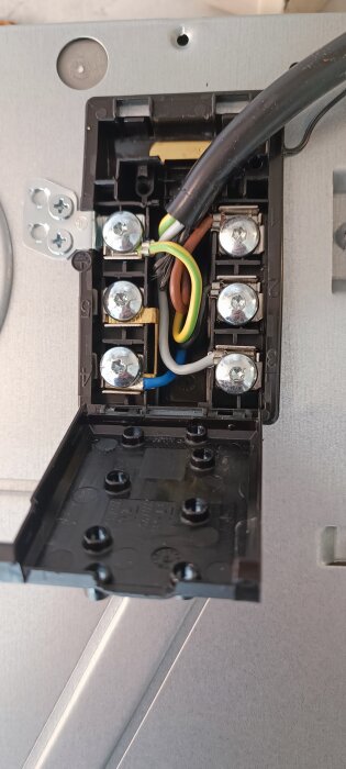 Öppen eluttaget med anslutna ledningar och kablar visar, installation eller reparation pågår.