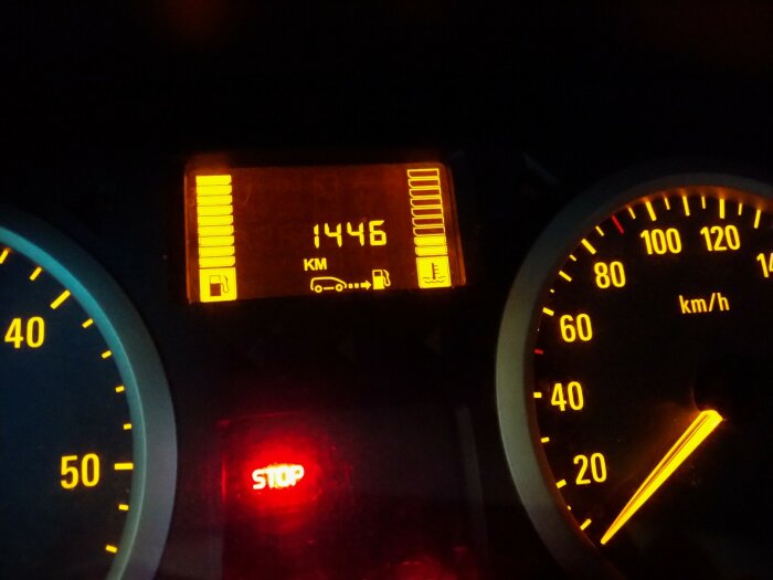 Fordonets instrumentbräda med bränslemätare, hastighetsmätare och varningslampa som visar "STOP".