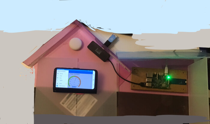 Smart hem-setup, sensorer, elektronik och skärm som visar energikonsumtion, kopplade till en husautomatiseringssystem.