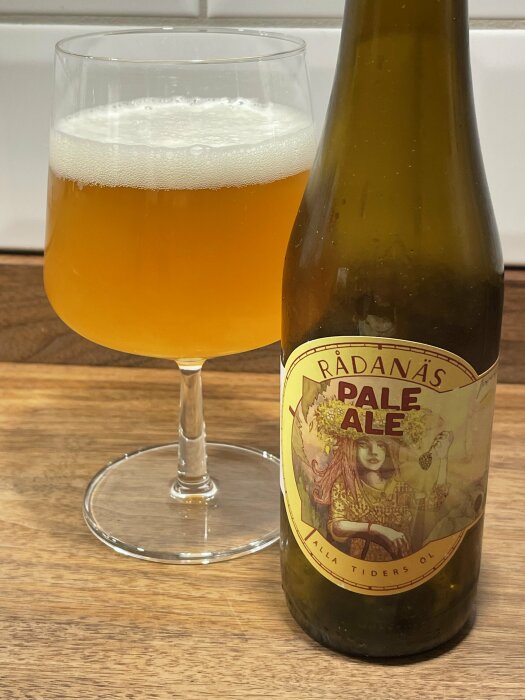 Flaska och glas med öl mot vit bakgrund, etikett säger "Rådanäs Pale Ale".