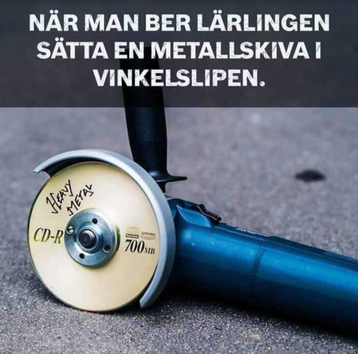 Vinkelslip med CD-skiva som skärskiva, humoristisk text, asfalt i bakgrunden.