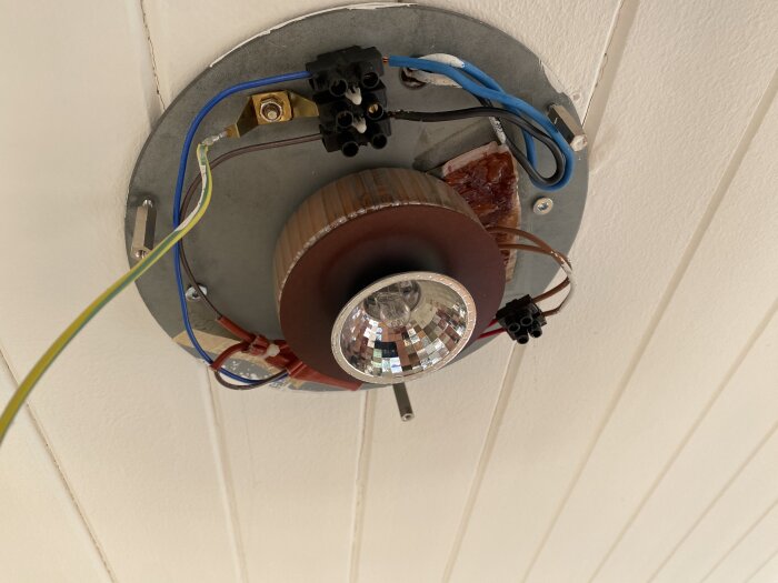 Öppen taklampa med synliga kablar och glödlampa, under installation eller reparation, mot vit takbakgrund.