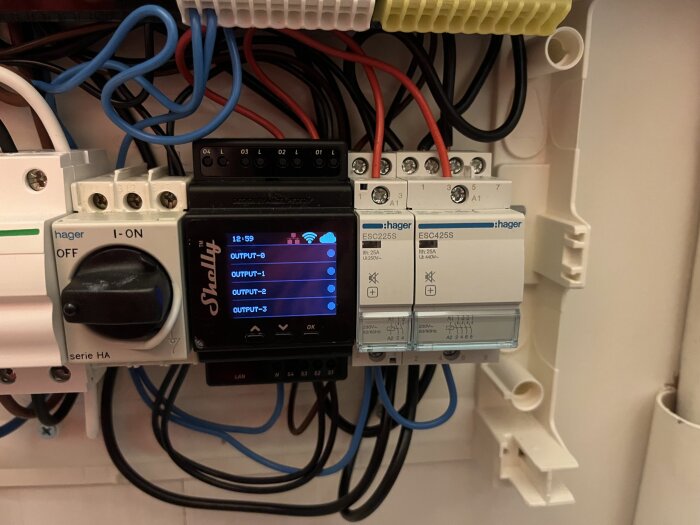 Elskåp med säkringar, manöverdon, digital skärm visar output-nivåer, elektriska kablar, installationsutrustning.