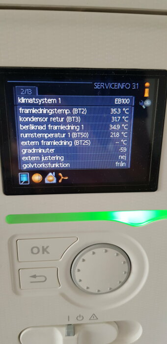 Digital kontrollpanel för klimatsystem med temperaturdisplay och knappar, indikerande servicebehov.