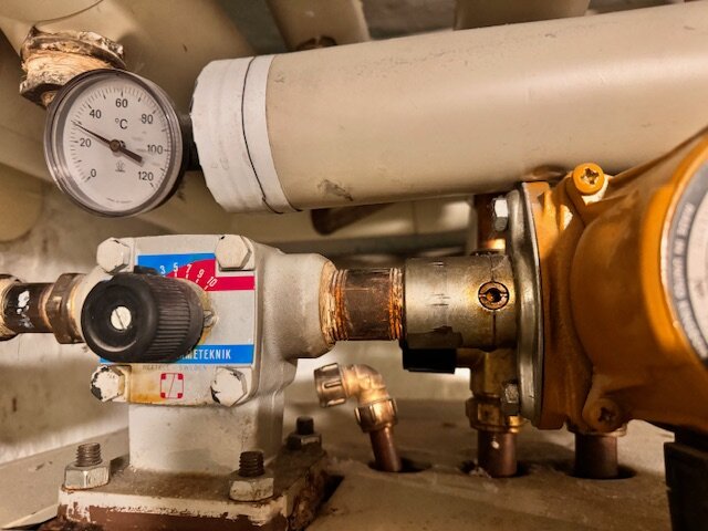 Mätare, rör och ventil i ett tekniskt installationssystem.