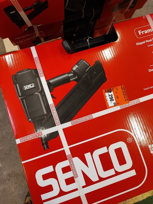 En SENCO spikpistol förpackning med säkerhetsband i butiksmiljö.