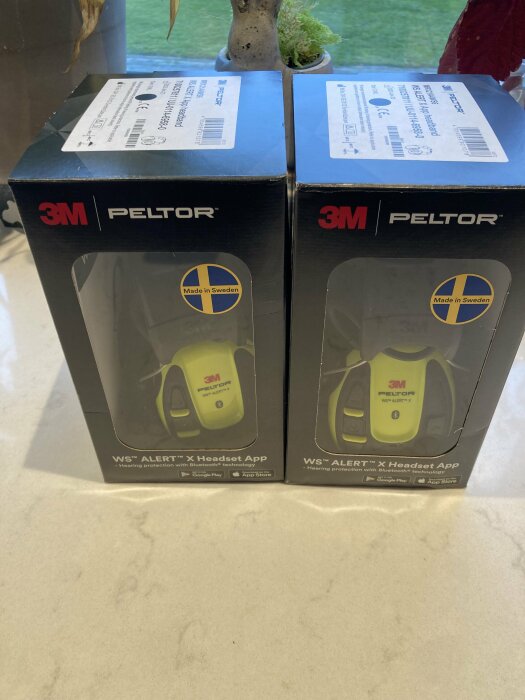 Två förpackningar med 3M Peltor hörselskydd, "Made in Sweden"-märke, Bluetooth-teknologi.