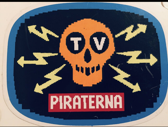 Orange dödskalle, texten "TV" och "PIRATERNA", blixtar, blå bakgrund, grafisk dekal eller klistermärke.