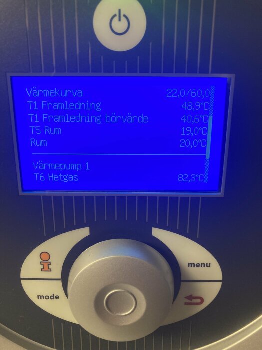 Digital display på värmesystem med temperaturvärden och knappar för ström, läge och meny.