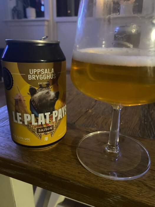 Ölburk från Uppsala Brygghus. Ölglas med ljus öl. Träbord. "Le Plat Pays" Saison. Est 2017. Inomhus.