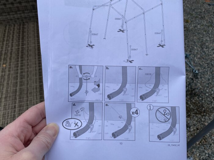 Instruktioner för montering av möbler på papper, hand håller pappret, ute, steg-för-steg illustrationer, skruvar och delar.