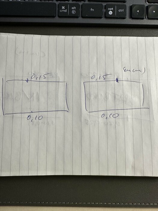 Handritade diagram på linjerat papper med måttangivelser, placerade ovanpå ett tangentbord.