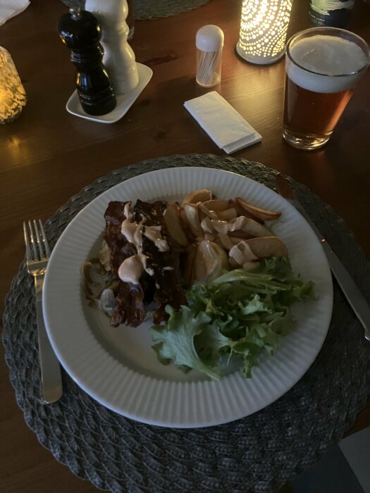 Middagsdukning: revbensspjäll, klyftpotatis, sallad, ölglas, kryddkvarnar, ljus, mysig atmosfär.