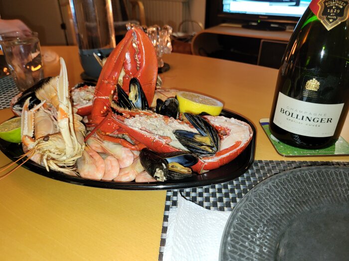 Skaldjursfat med krabba, räkor, musslor, citron, Bollinger-champagneflaska, middagsbord, matservis.