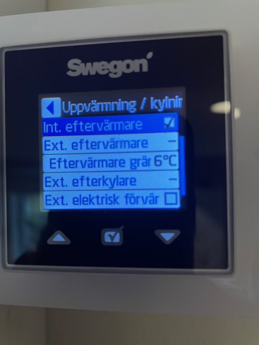 Digital display med svenska menyalternativ för uppvärmning och kylsystem, knappar för navigering, märkt "Swegon".