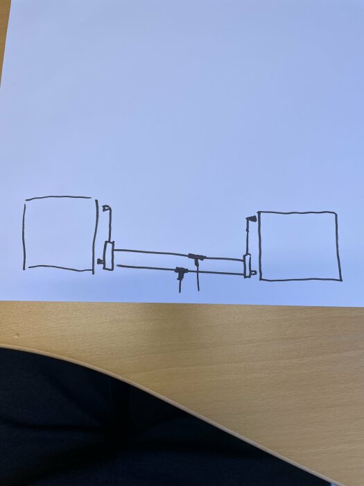 Enkelt handritat diagram av vad som kan vara en datorkrets eller kopplingsschema ligger på ett bord.