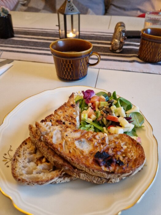 Mysig fikastund med rostat bröd, sallad, kaffe och ljus i hemmiljö.