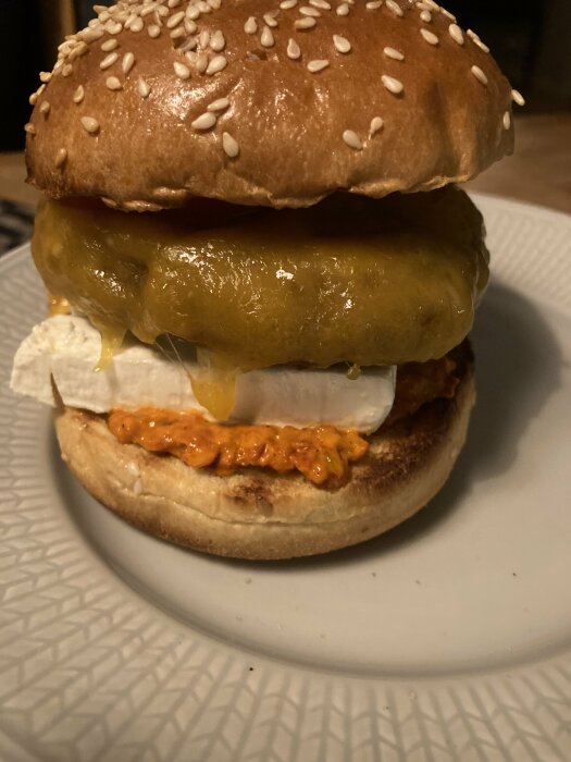 Sesambagel med vitost, paprika, stor inlagd gurka på mönstrad tallrik.