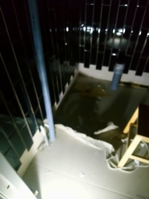 Suddig bild, balkong eller veranda på natten, konstgjort ljus, vått golv, möbler synliga, staket, utomhusmiljö.