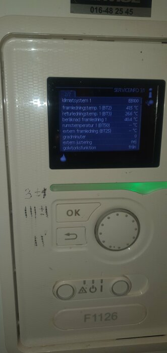 Värmepumpsdisplay visar temperaturinformation och driftstatus. Kontrollknappar och servicekod nedanför. Använd spelutrymme, slitage synligt.