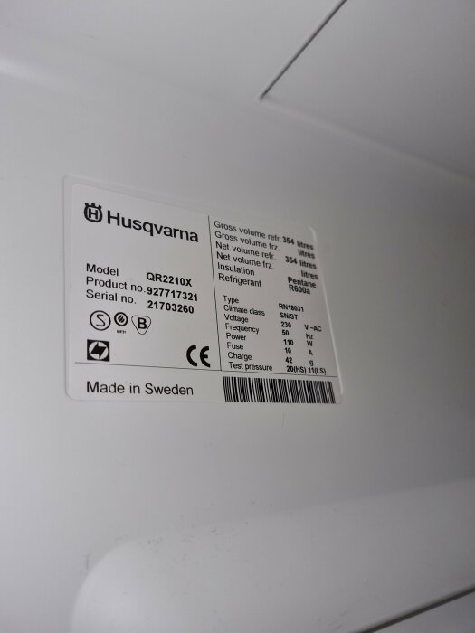 Specifikationsetikett för Husqvarna-kylskåp med modellnummer, serienummer, volym och elspecifikationer; tillverkad i Sverige.