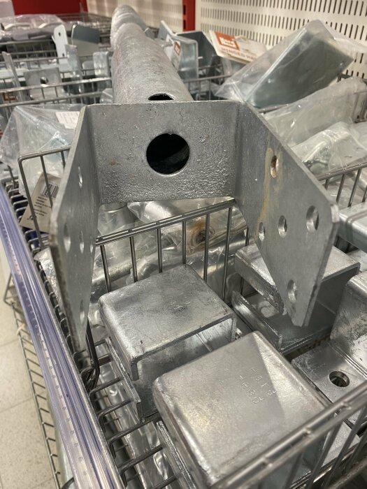 Metallstolpar och beslag i en korg i en byggmarknad eller järnaffär.