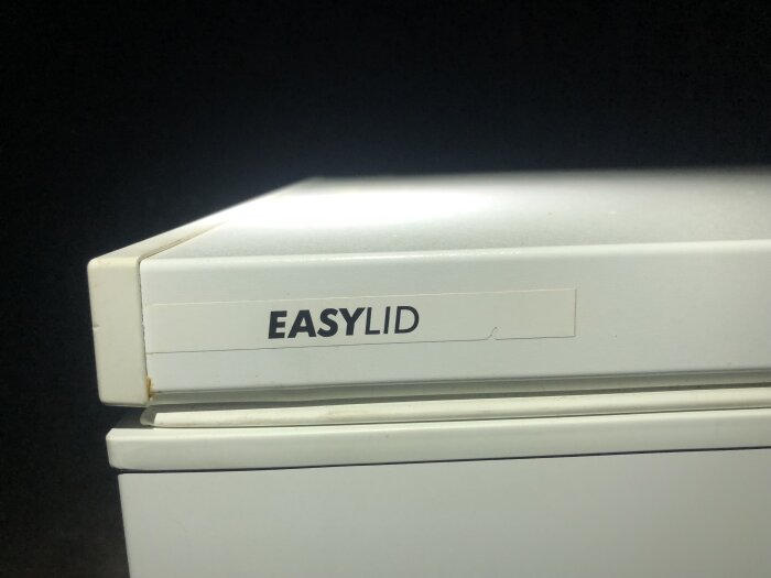 Vit maskin med texten "EASYLID", möjligtvis en del av en större apparat.