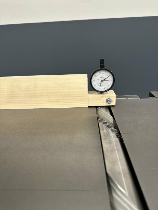 Mätur verktyg monterat vid sågblad kontrollerar träets position på arbetsbänk.
