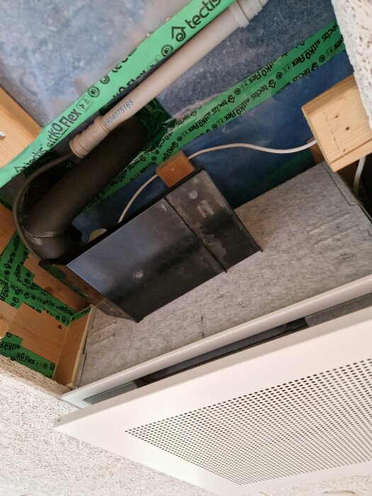 Takutsnitt med isolering, ventilationsrör, elledningar och en del av en luftventil.