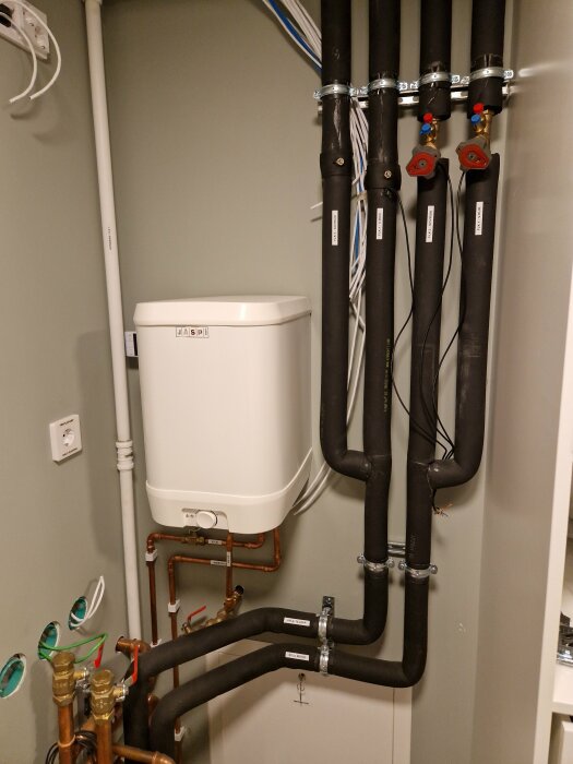 VVS-installation, expansionskärl, rör, ventiler, isolering, tekniskt rum, installation för uppvärmning eller vatten.