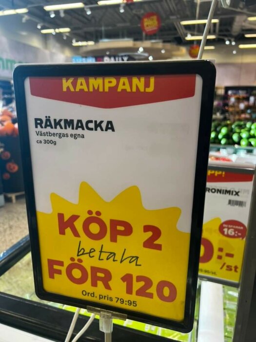 Reklamskylt för kampanj på "räkmacka", erbjudande: köp två för 120 kronor, i butiksmiljö.