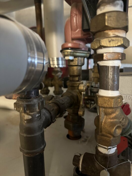 Rörledningar, ventiler och kopplingar i ett tekniskt system eller installation, möjligen för vatten eller uppvärmning.