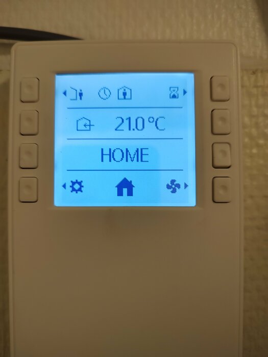 Digital termostat visar 21.0°C, hemikon, menyer, knappar på sidan.