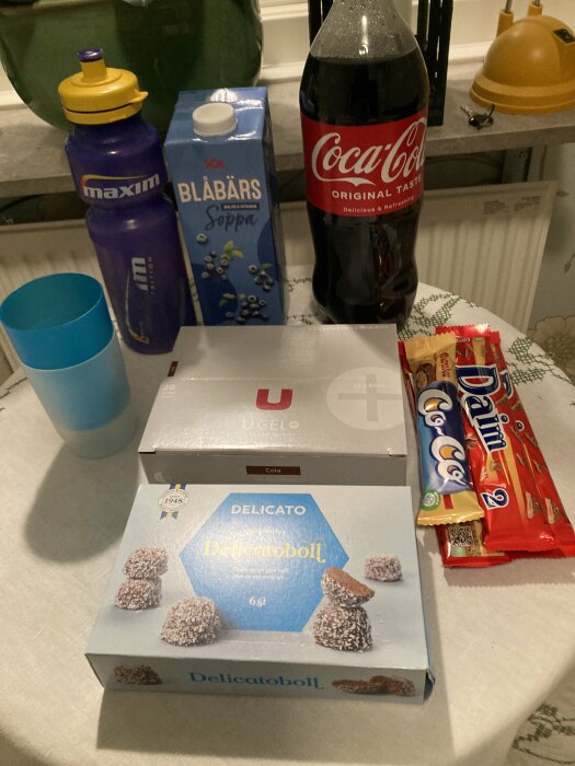 Fika med snacks, drycker, chokladkex, blåbärssoppa och sportdryck på köksbänk.