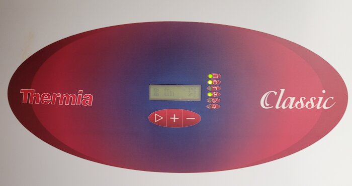 Värmepumpspanel med märket "Thermia", display, knappar, röd bakgrund, "Classic" text, statusindikatorer.