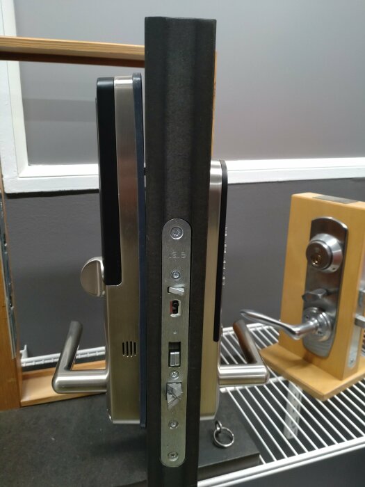 Metall säkerhetsdörr med kortläsare, kodlås och handtag vid sidan av en annan dörrhandtagsmodell.
