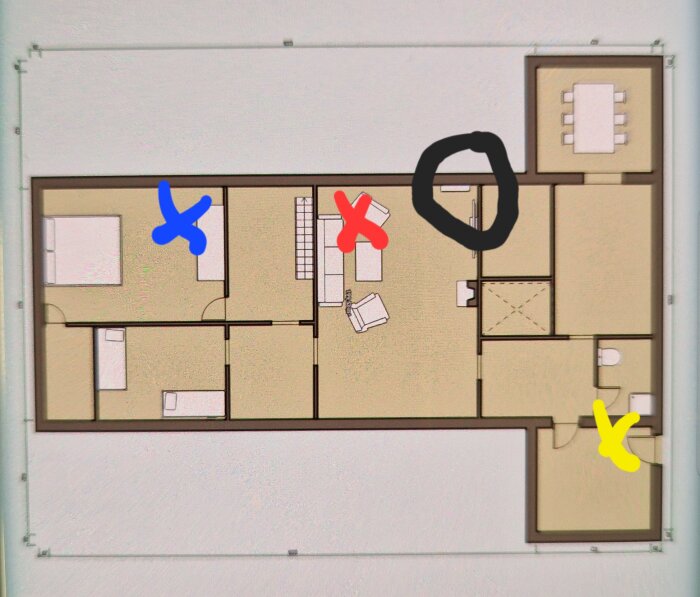 Ritning av byggnadens layout med färgade markeringar: blått kryss, rött kryss, svart cirkel, gult kryss.