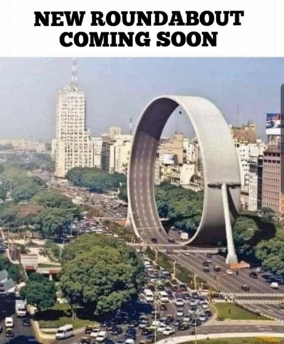 Stadsbild med trafik, humoristisk photoshoppad rondell formad som vertikal loop, skyskrapor i bakgrunden, "NEW ROUNDABOUT COMING SOON" text.