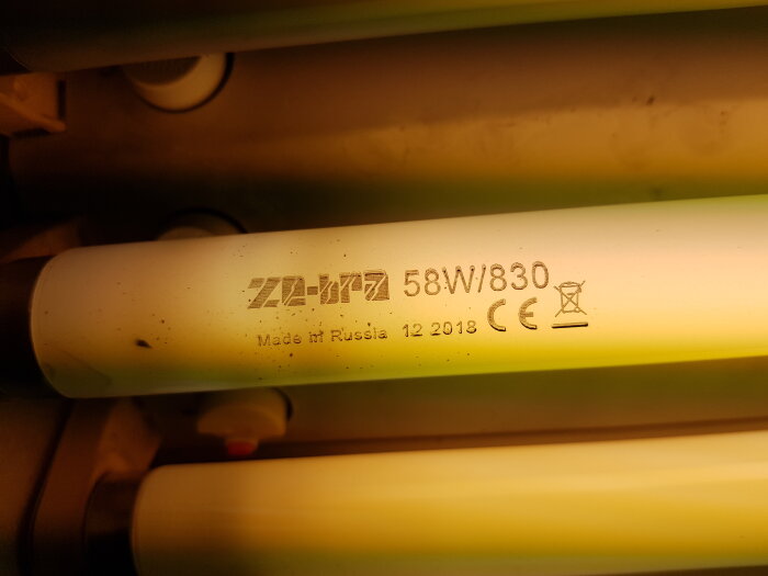 Fluorescerande ljusrör, märkning, "Made in Russia", datum, 58W, varmt ljus, dammigt, närbild.