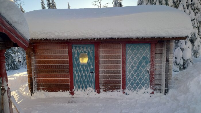 Tjockt snötäcke på taket, tre dörrar, frostigt, vinterlandskap, timmerhus, sol genom frostad glassruta.