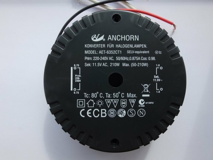 Elektronisk transformator för halogenlampor, 220-240V till 11.5V, svart, etiketter och säkerhetsmärkningar, två kablar.