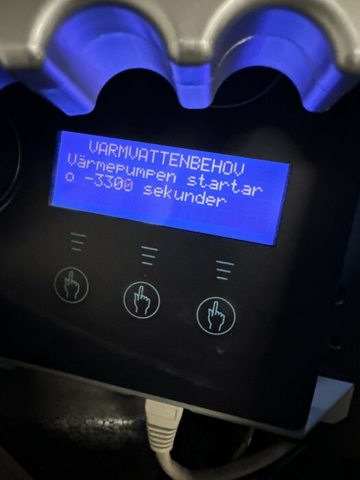 Digital display, blå bakgrund, text på svenska, uppvärmningsanordningens gränssnitt, ikoner för handstyrning.