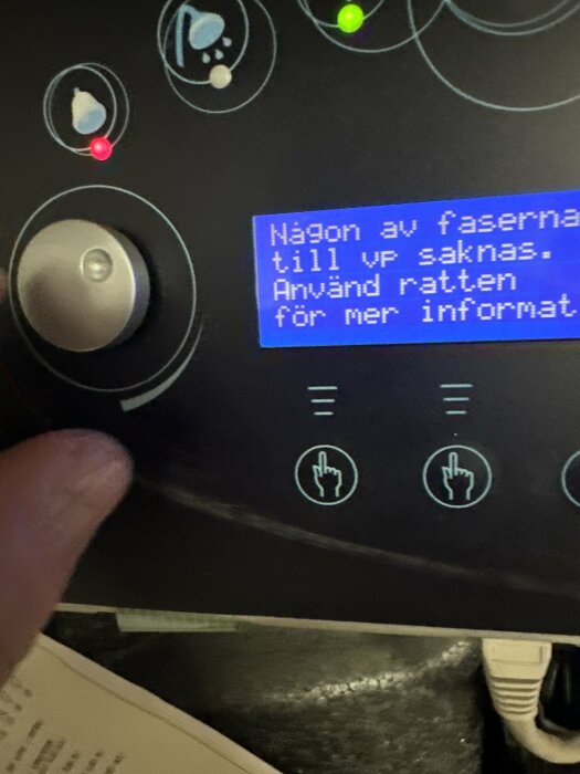 Maskinpanel med knappar, kontrollhjul, statuslampor och svensk text på display: "Någon av faserna till vp saknas. Använd ratten för mer information".